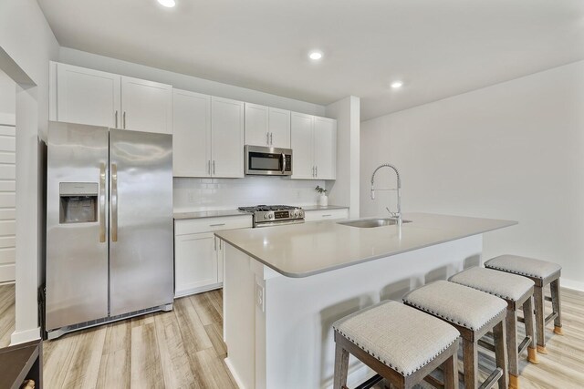 380 Gingerwood Ln, Hendersonville, TN 37075 - kitchen featuring appliances with stainless steel finishes, a sink, light wood-style flooring, white cabinetry, and recessed lighting