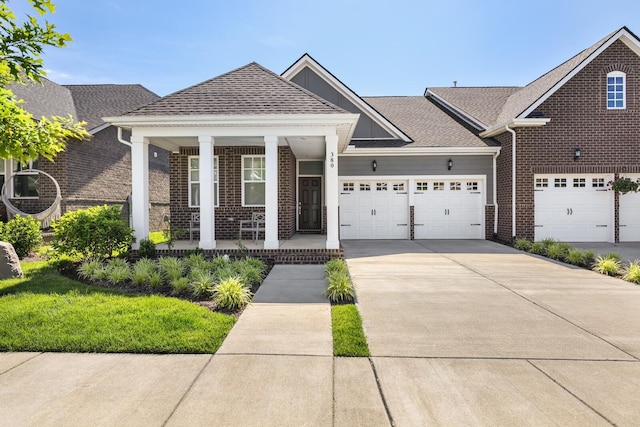 380 Gingerwood Ln, Hendersonville, TN 37075 - view of front of house featuring a porch, brick siding, driveway, an attached garage, and roof with shingles