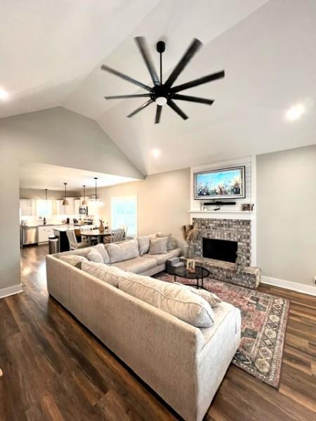 204 Julia Ann Ct, Springfield, TN 37172 - living area featuring a ceiling fan, lofted ceiling, dark wood-style flooring, a large fireplace, and baseboards