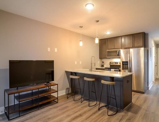 2507 Clifton Ave Unit 104, Nashville, TN 37209 - kitchen featuring stainless steel appliances, a peninsula, light wood-style flooring, and a sink