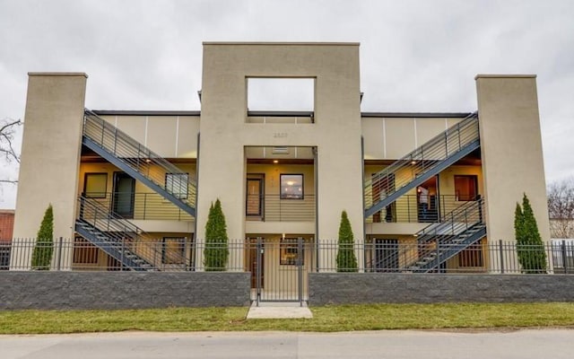 2507 Clifton Ave Unit 104, Nashville, TN 37209 - view of front of property featuring a fenced front yard, stucco siding, and stairway