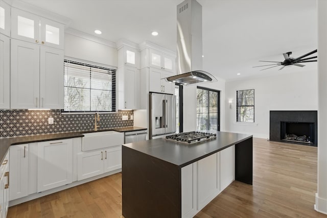 329 Lawndale Dr, Nashville, TN 37217 - kitchen featuring appliances with stainless steel finishes, a sink, island exhaust hood, dark countertops, and light wood-style flooring