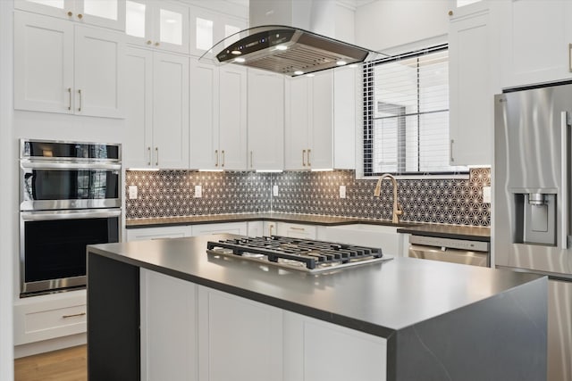 329 Lawndale Dr, Nashville, TN 37217 - kitchen with stainless steel appliances, island range hood, dark countertops, tasteful backsplash, and a sink