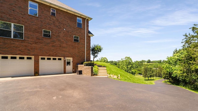 1056 Gilmore Hill Rd, Lebanon, TN 37087 - view of side of property featuring asphalt driveway, a garage, and brick siding