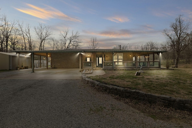 10669 S Windrow Rd, Rockvale, TN 37153 - mid-century home featuring gravel driveway, an attached carport, a porch, and brick siding