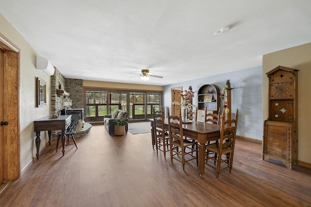 10669 S Windrow Rd, Rockvale, TN 37153 - dining room with wood finished floors, a ceiling fan, a wall mounted AC, baseboards, and a fireplace
