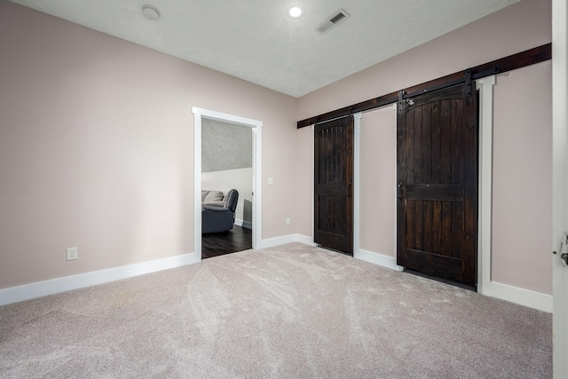 11 Walnut Creek Dr, Manchester, TN 37355 - unfurnished bedroom with a barn door, carpet flooring, and baseboards