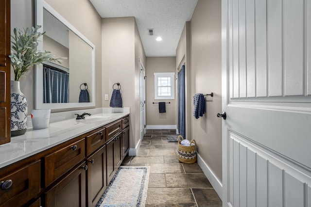 11 Walnut Creek Dr, Manchester, TN 37355 - bathroom featuring baseboards, vanity, stone tile flooring, and a textured ceiling