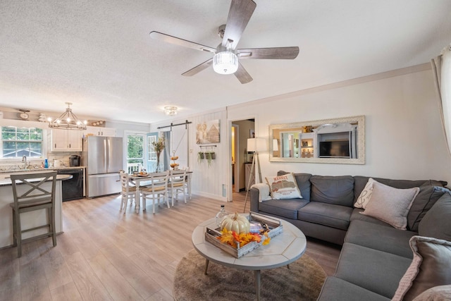 5935 Old Stage Rd, Huntingdon, TN 38344 - living area featuring healthy amount of natural light, light wood finished floors, ceiling fan, a chandelier, and a textured ceiling