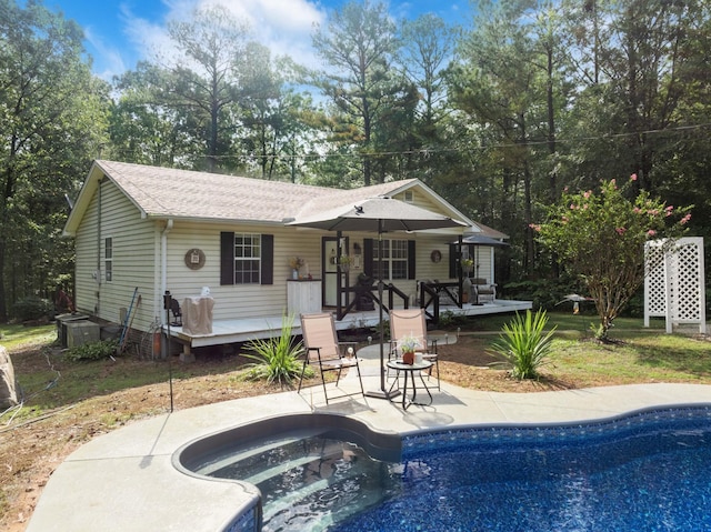 5935 Old Stage Rd, Huntingdon, TN 38344 - back of property with a deck, an outdoor pool, a patio, and a shingled roof
