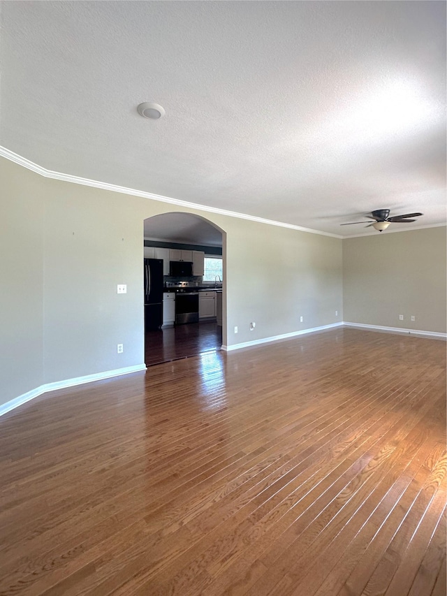 730 Everville Dr, Livingston, TN 38570 - spare room featuring ornamental molding, ceiling fan, arched walkways, dark wood-type flooring, and baseboards