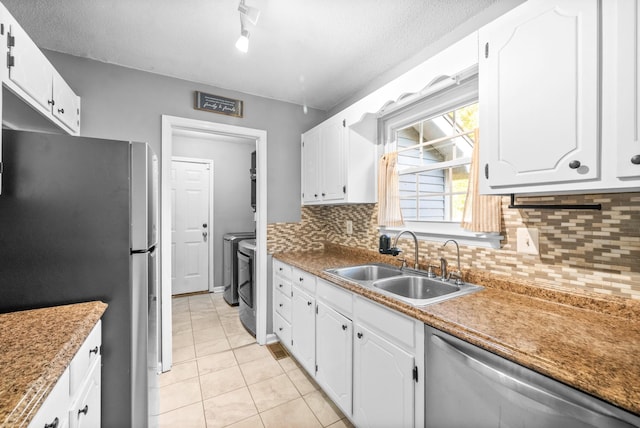 517 Ginkgo Dr, Clarksville, TN 37042 - kitchen featuring stainless steel appliances, separate washer and dryer, a sink, white cabinetry, and light tile patterned flooring