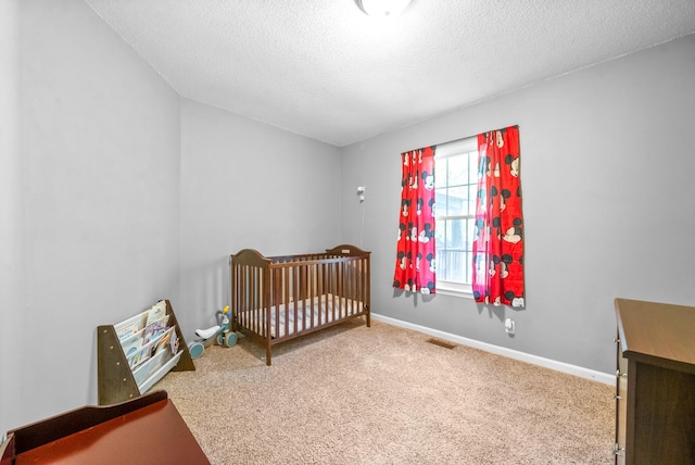 517 Ginkgo Dr, Clarksville, TN 37042 - carpeted bedroom featuring a textured ceiling, a nursery area, and baseboards