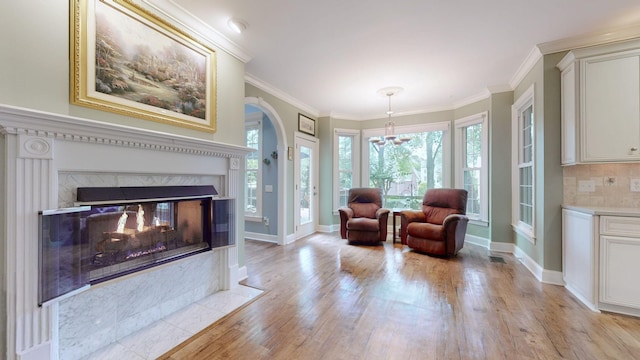103 Doral Ln, Hendersonville, TN 37075 - living area featuring arched walkways, light wood-style flooring, a chandelier, ornamental molding, and baseboards
