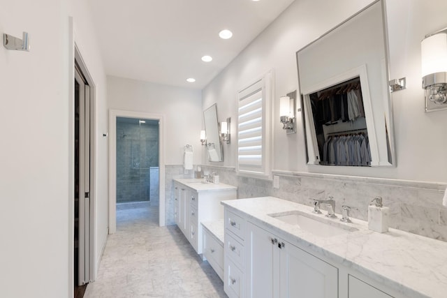 143 Prospect Hl, Nashville, TN 37205 - full bathroom featuring two vanities, tiled shower, tile walls, a spacious closet, and recessed lighting