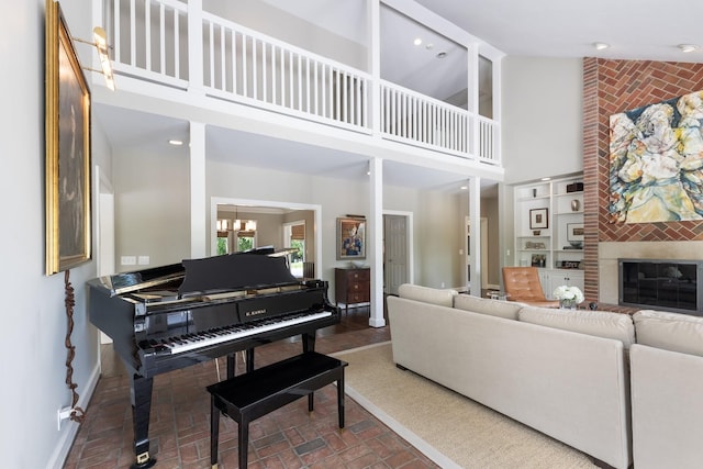 143 Prospect Hl, Nashville, TN 37205 - living room with high vaulted ceiling, brick patterned floors, a large fireplace, a chandelier, and baseboards