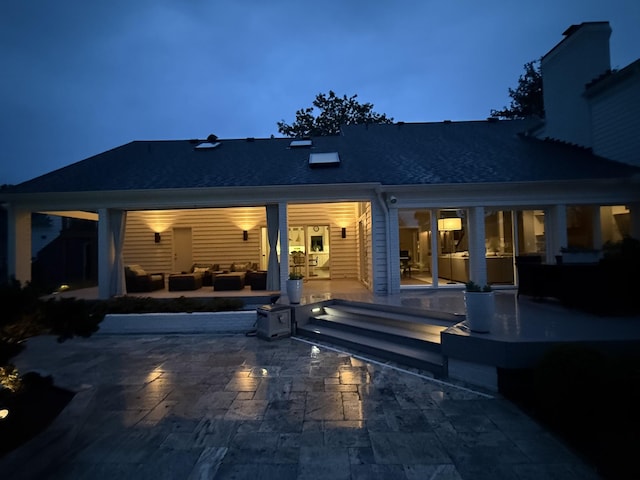 143 Prospect Hl, Nashville, TN 37205 - back of house at twilight with outdoor lounge area, a patio area, and a chimney