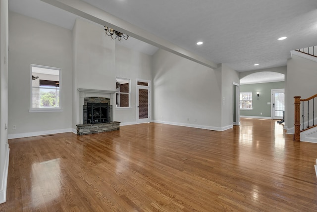 3840 SE Tater Peeler Rd, Lebanon, TN 37090 - unfurnished living room featuring stairs, arched walkways, a fireplace, wood finished floors, and recessed lighting