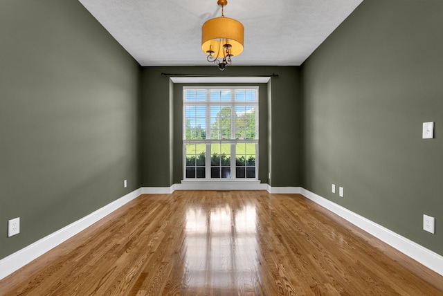 3840 SE Tater Peeler Rd, Lebanon, TN 37090 - empty room featuring wood finished floors, baseboards, and a chandelier