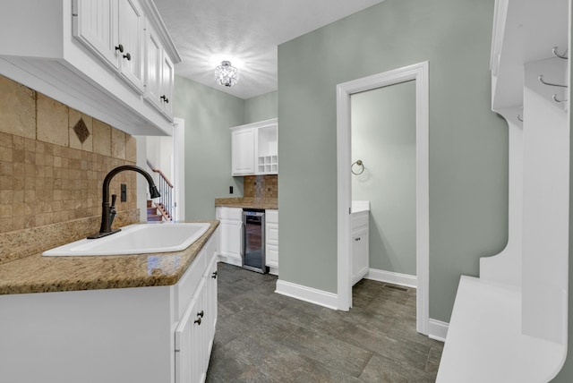 3840 SE Tater Peeler Rd, Lebanon, TN 37090 - kitchen with a sink, beverage cooler, tasteful backsplash, white cabinets, and baseboards