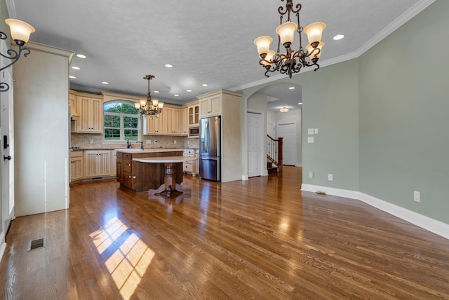 3840 SE Tater Peeler Rd, Lebanon, TN 37090 - kitchen featuring stainless steel appliances, a chandelier, arched walkways, cream cabinetry, and ornamental molding