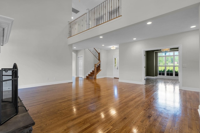 3840 SE Tater Peeler Rd, Lebanon, TN 37090 - unfurnished living room with stairs, wood finished floors, baseboards, recessed lighting, and a towering ceiling