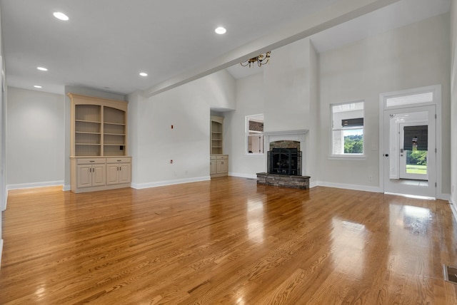 3840 SE Tater Peeler Rd, Lebanon, TN 37090 - unfurnished living room featuring baseboards, built in features, a fireplace, recessed lighting, and high vaulted ceiling