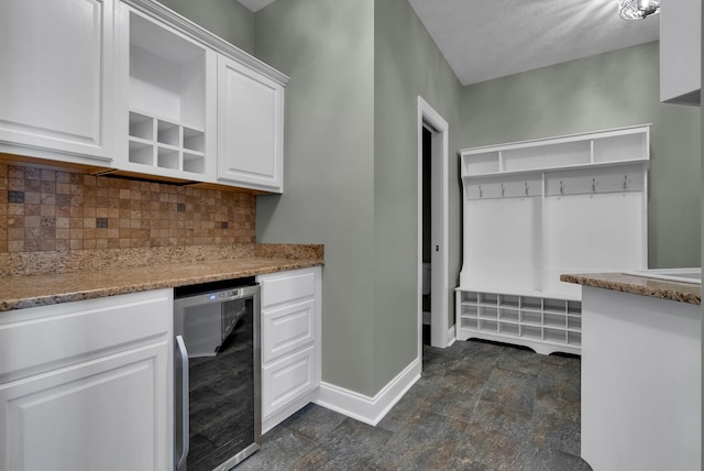 3840 SE Tater Peeler Rd, Lebanon, TN 37090 - indoor dry bar featuring wine cooler, baseboards, tasteful backsplash, dark stone finish floors, and a textured ceiling