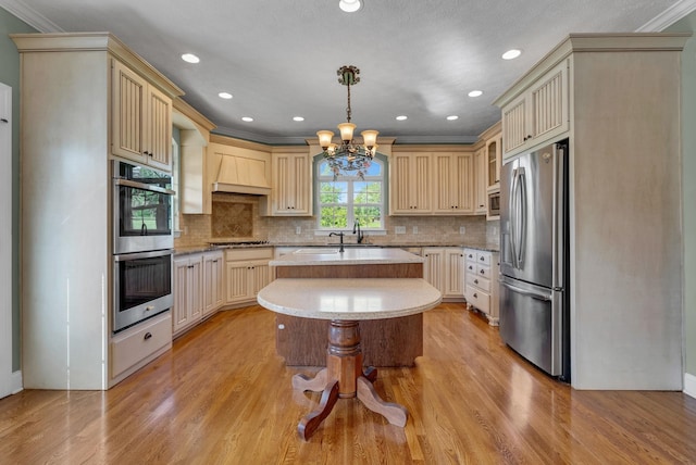 3840 SE Tater Peeler Rd, Lebanon, TN 37090 - kitchen with appliances with stainless steel finishes, cream cabinetry, a center island, a chandelier, and light wood finished floors