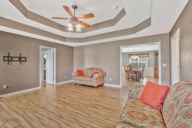 2137 Horton Way, Lewisburg, TN 37091 - living room with a raised ceiling, light wood-style flooring, ceiling fan, baseboards, and a chandelier