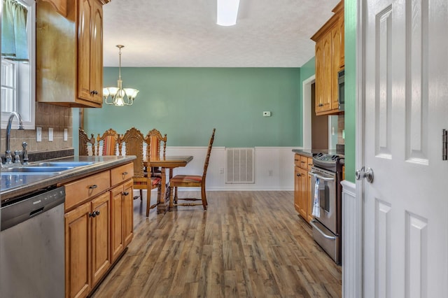 2137 Horton Way, Lewisburg, TN 37091 - kitchen with stainless steel appliances, a sink, dark countertops, wood finished floors, and wainscoting
