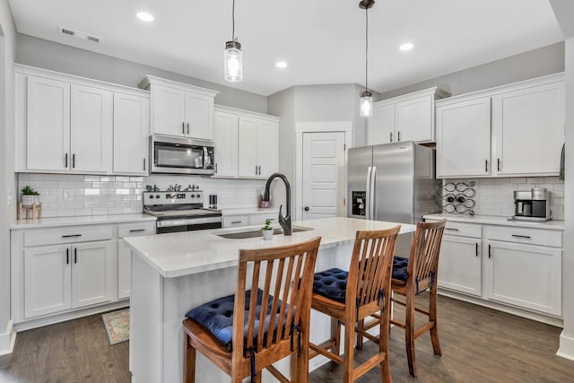 1114 Johnson St, Burns, TN 37029 - kitchen with stainless steel appliances, a sink, light countertops, backsplash, and dark wood-style flooring
