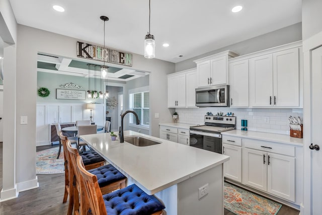 1114 Johnson St, Burns, TN 37029 - kitchen with stainless steel appliances, a sink, a kitchen breakfast bar, tasteful backsplash, and an island with sink