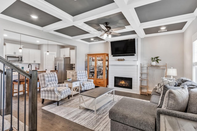 1114 Johnson St, Burns, TN 37029 - living room featuring dark wood-style flooring, a large fireplace, coffered ceiling, beam ceiling, and ceiling fan