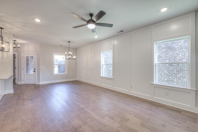 9067 Headwaters Dr Unit 141, Franklin, TN 37064 - unfurnished living room with a chandelier, a decorative wall, ceiling fan, wood finished floors, and recessed lighting