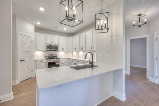 9067 Headwaters Dr Unit 141, Franklin, TN 37064 - kitchen featuring appliances with stainless steel finishes, a chandelier, a sink, light wood-style flooring, and recessed lighting