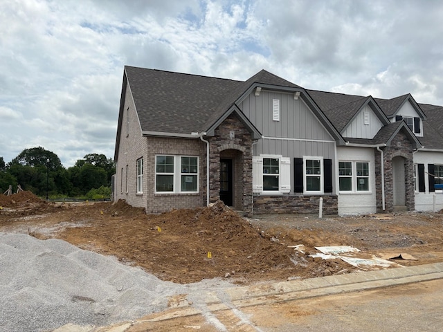 9067 Headwaters Dr Unit 141, Franklin, TN 37064 - view of front of house featuring board and batten siding, roof with shingles, and stone siding