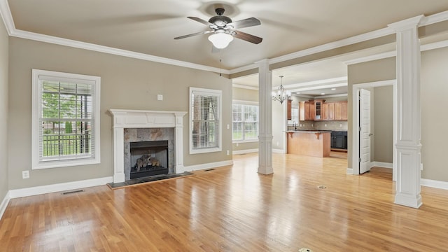 1023 Fitzroy Cir, Spring Hill, TN 37174 - unfurnished living room featuring ornate columns, a premium fireplace, plenty of natural light, crown molding, and light wood-style flooring