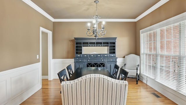 1023 Fitzroy Cir, Spring Hill, TN 37174 - dining area featuring a chandelier, light wood finished floors, healthy amount of natural light, ornamental molding, and wainscoting