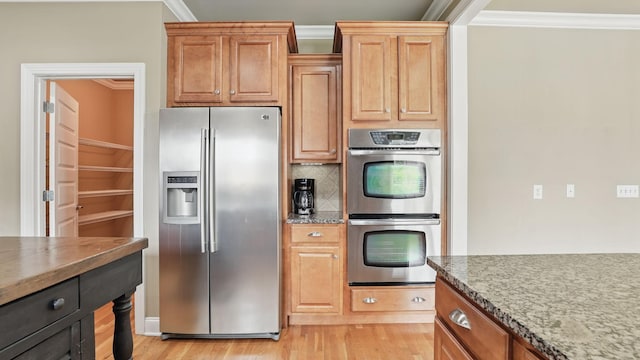 1023 Fitzroy Cir, Spring Hill, TN 37174 - kitchen with stainless steel appliances, ornamental molding, light wood-style flooring, tasteful backsplash, and dark stone countertops