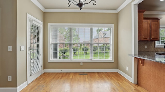 1023 Fitzroy Cir, Spring Hill, TN 37174 - unfurnished dining area with light wood-type flooring, crown molding, and a chandelier
