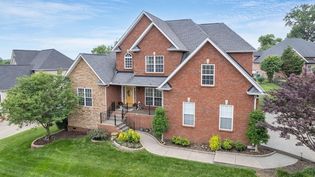1023 Fitzroy Cir, Spring Hill, TN 37174 - traditional-style house featuring a front yard, brick siding, roof with shingles, and stone siding