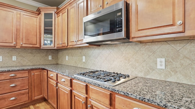 1023 Fitzroy Cir, Spring Hill, TN 37174 - kitchen featuring stainless steel appliances, crown molding, light stone countertops, glass insert cabinets, and backsplash
