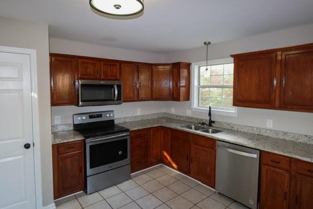 6356 Paddington Way, Antioch, TN 37013 - kitchen featuring appliances with stainless steel finishes, a sink, light tile patterned floors, and pendant lighting