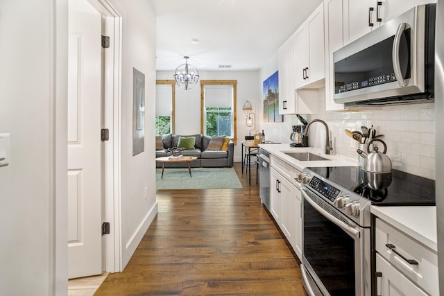 612 21st Ave N Unit 211, Nashville, TN 37203 - kitchen featuring stainless steel appliances, a sink, dark wood-style floors, backsplash, and white cabinets