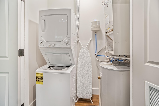 612 21st Ave N Unit 211, Nashville, TN 37203 - laundry area featuring stacked washer and clothes dryer, water heater, and wood finished floors