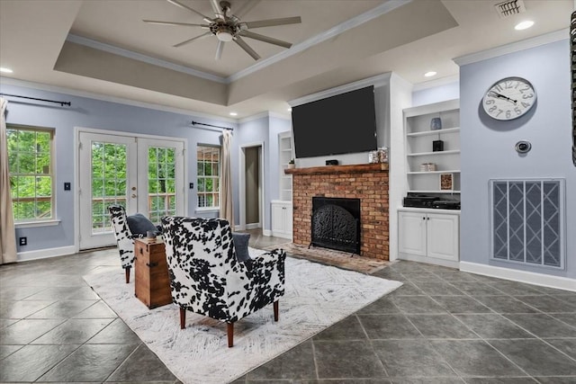 7244 Knottingham Dr, Fairview, TN 37062 - living area featuring crown molding, a raised ceiling, ceiling fan, baseboards, and a brick fireplace