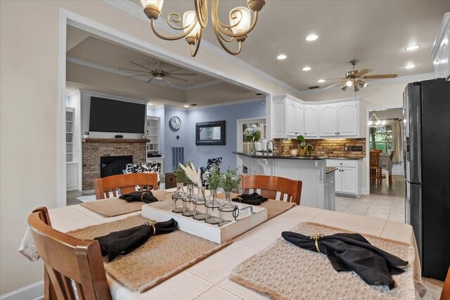 7244 Knottingham Dr, Fairview, TN 37062 - dining area with a ceiling fan, crown molding, recessed lighting, a fireplace, and a chandelier