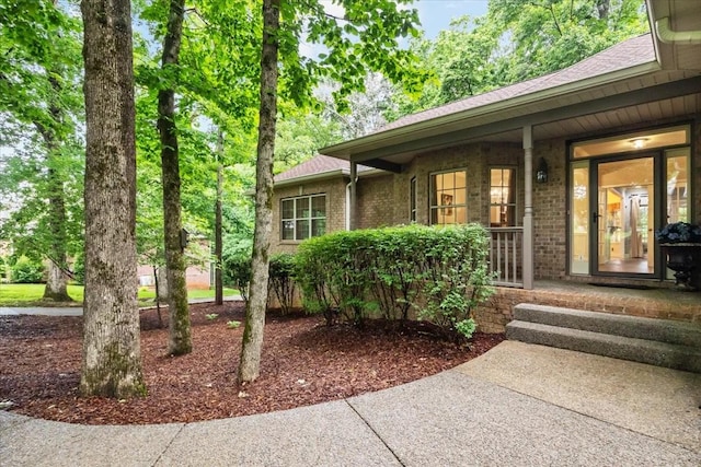 7244 Knottingham Dr, Fairview, TN 37062 - doorway to property with brick siding, roof with shingles, and a porch