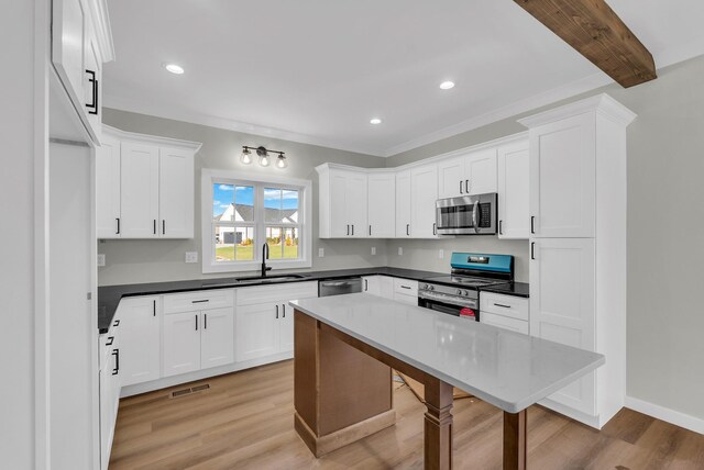 2600 Spring Arbor Ct, Cookeville, TN 38501 - kitchen featuring appliances with stainless steel finishes, a sink, white cabinets, light wood-style flooring, and a breakfast bar area